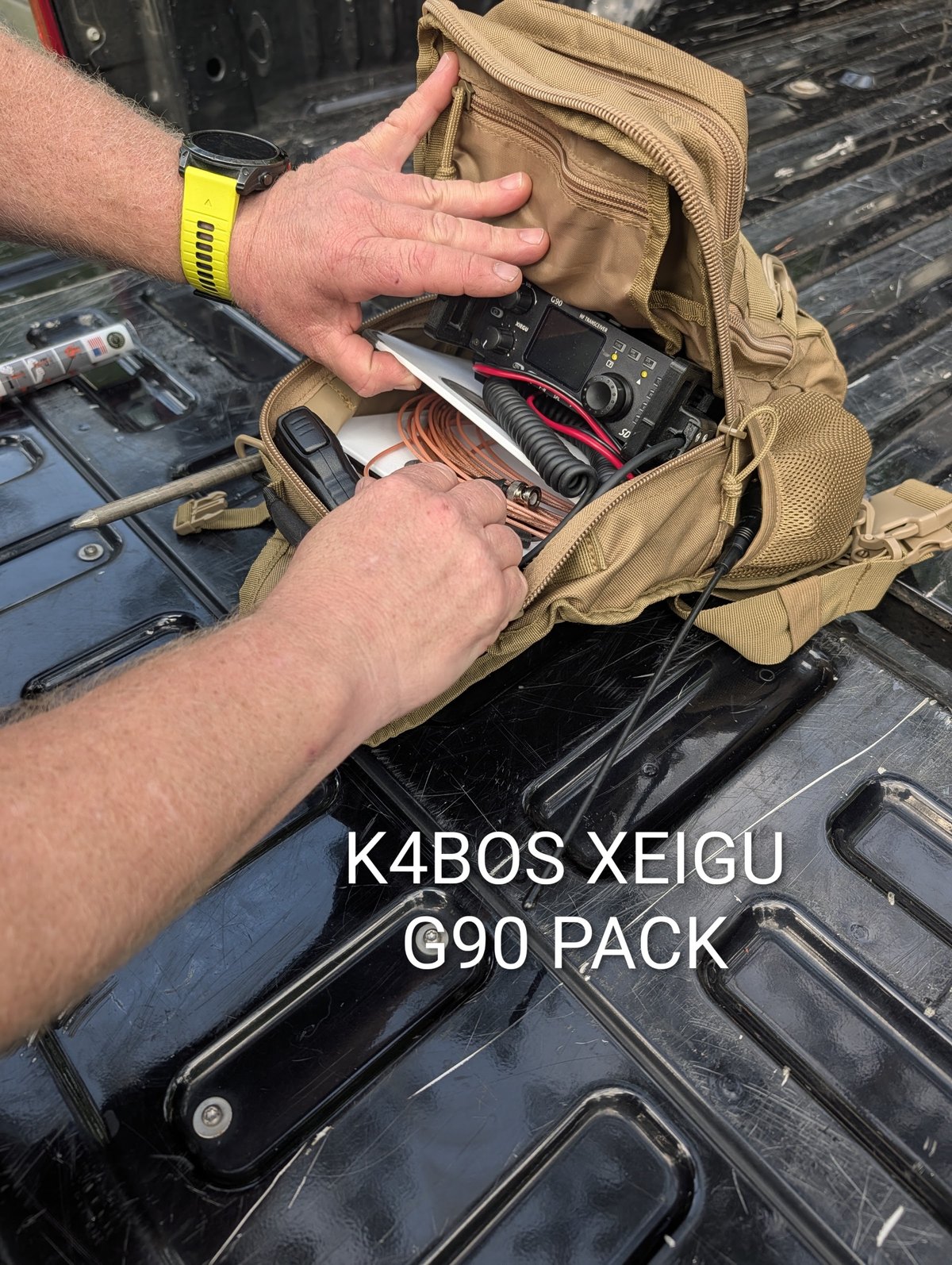 A shoulder pack opened in a truck bed containing a Xiegu G90, battery and coiled feedline, labelled K4BOS Xiegu G90 pack